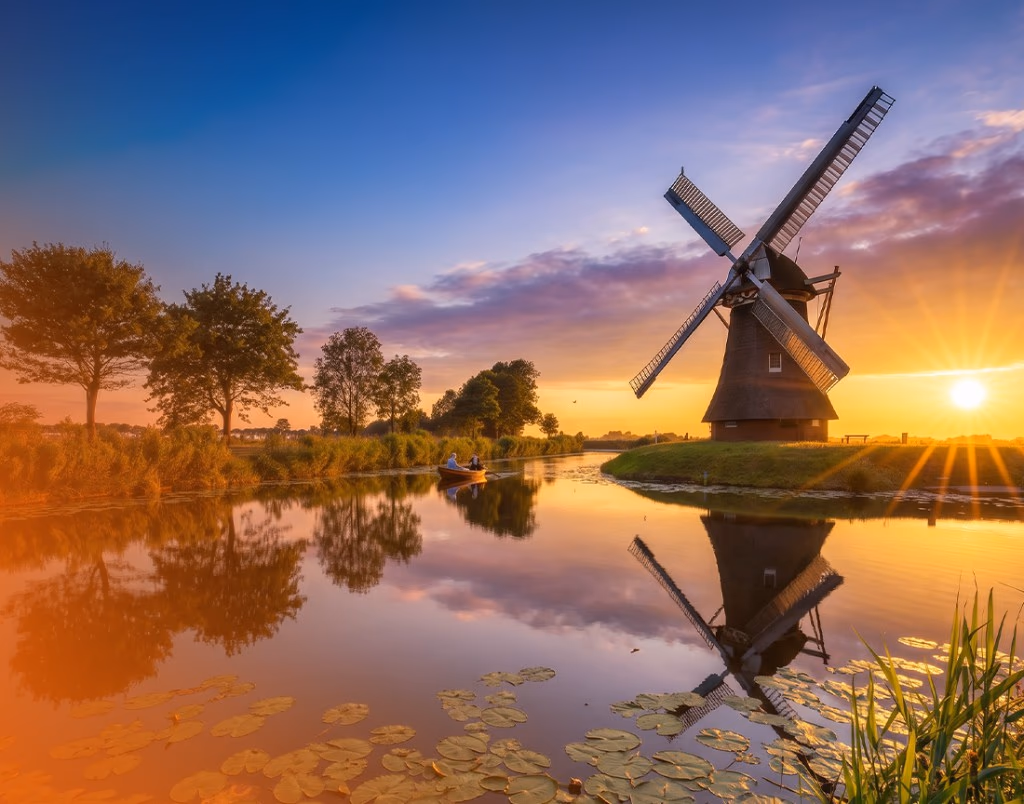 Traditional Dutch windmill reflected in a canal at sunset on a private countryside day tour from Amsterdam