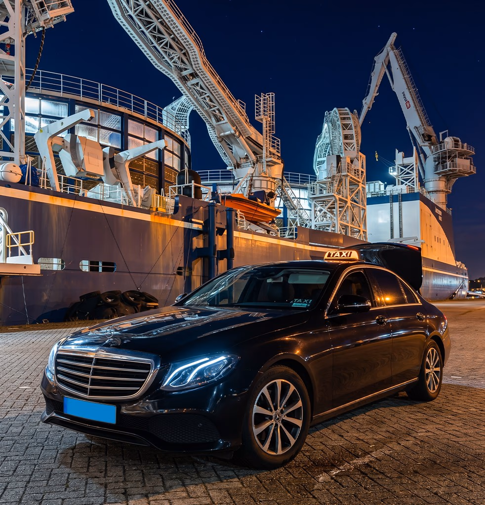 Amsterdam taxi Mercedes E-Class with a taxi sign beside a cruise ship at the Amsterdam passenger port