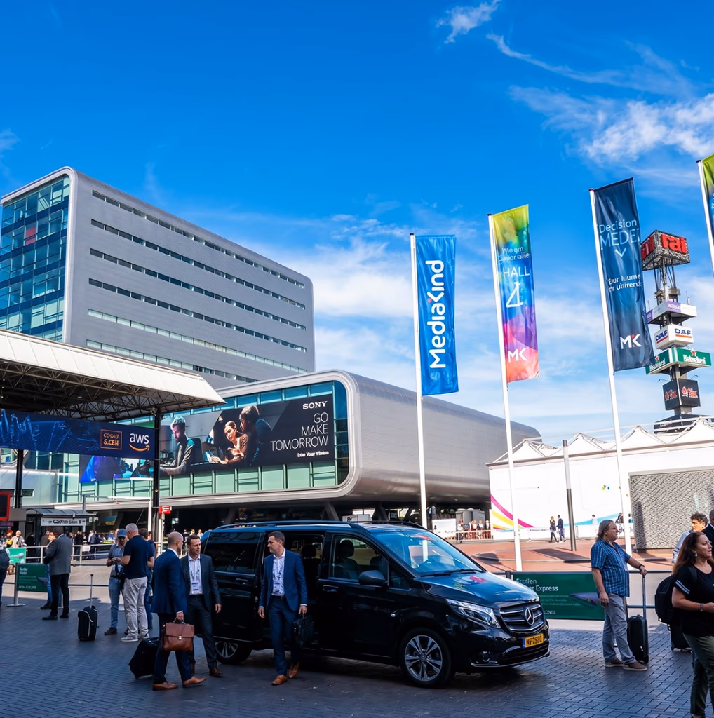 Business travellers with luggage boarding a Toursnl Mercedes V-Class van outside RAI Amsterdam during a convention