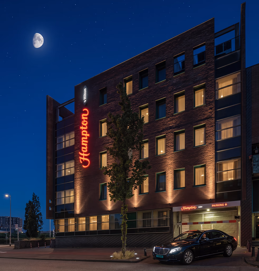 Private taxi in Amsterdam — black Mercedes S-Class waiting at night outside the Hampton by Hilton hotel