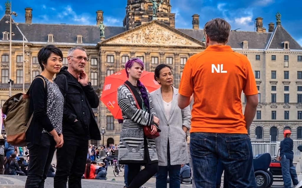 Private tours in the Netherlands — a Holland ToursNL guide with a small tour group at Dam Square, Amsterdam